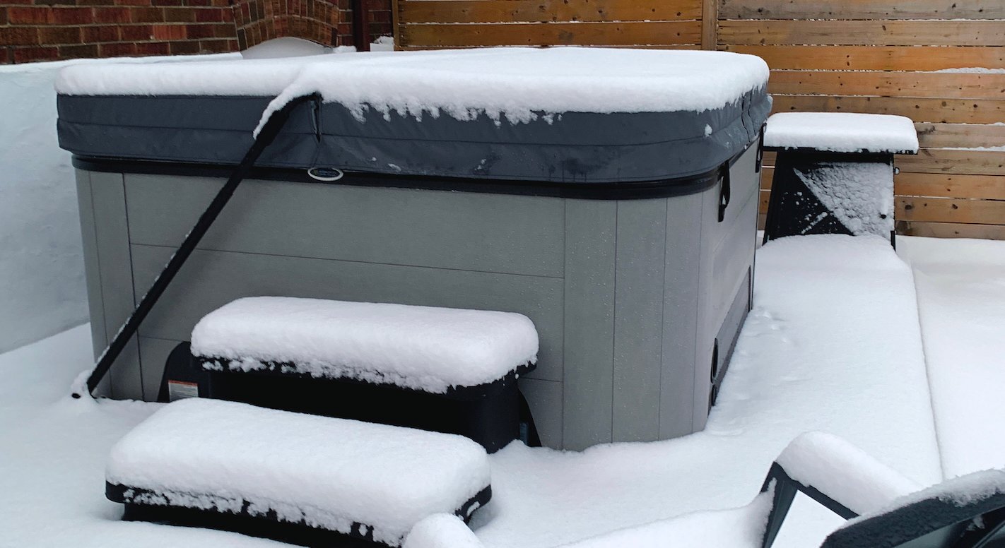 Snow piled on a Hydropool hot tub, showing how efficient it is as keeping heat locked in.