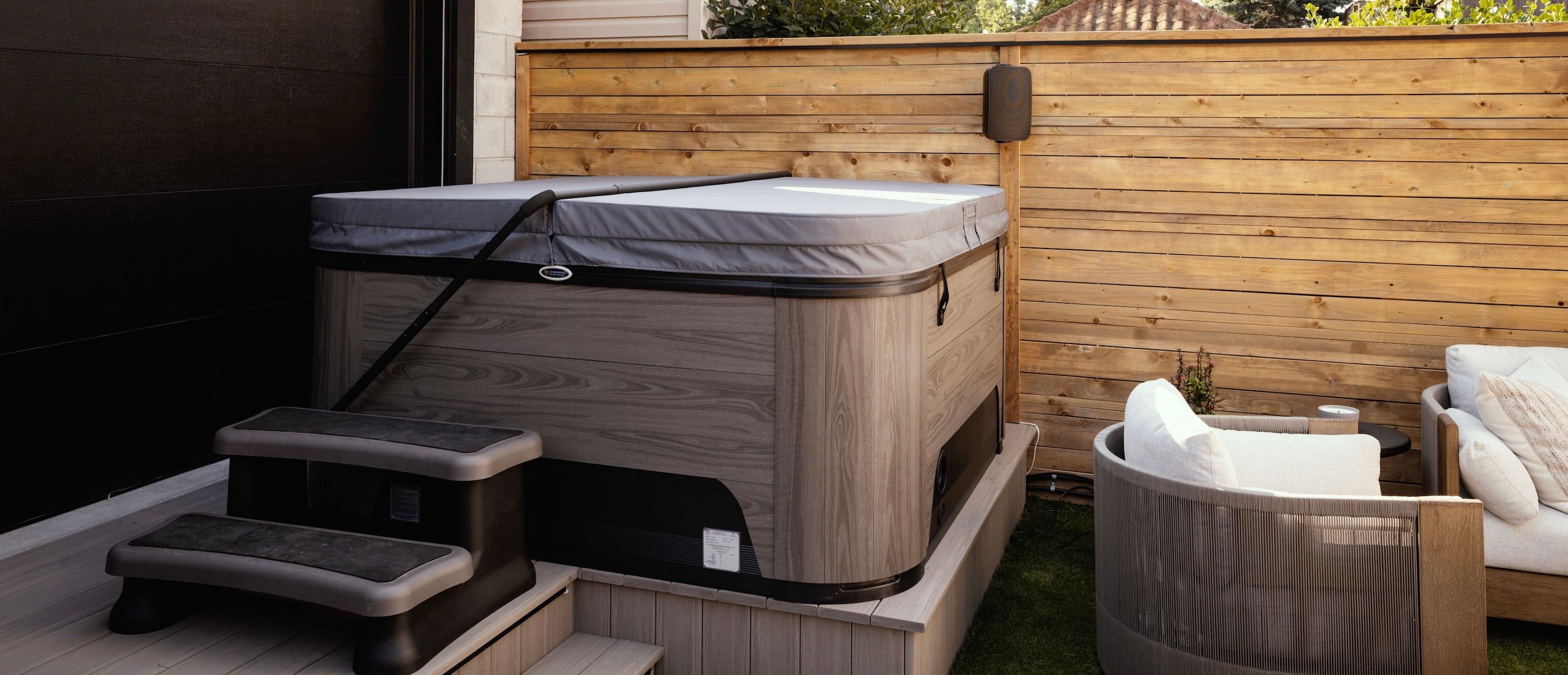 A luxury hot tub with cover and lifter.