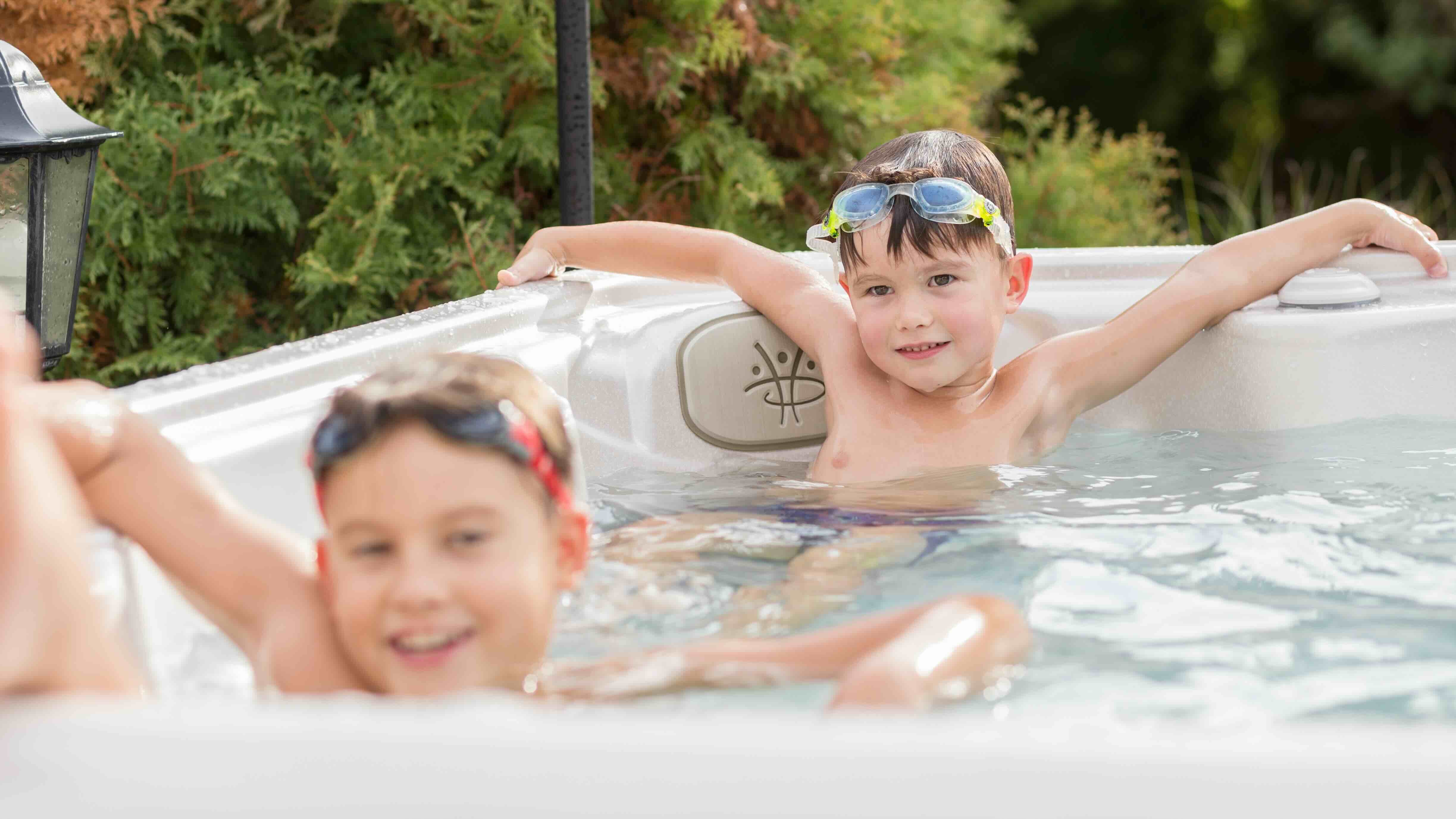Two boys relax in a Serenity hot tub.