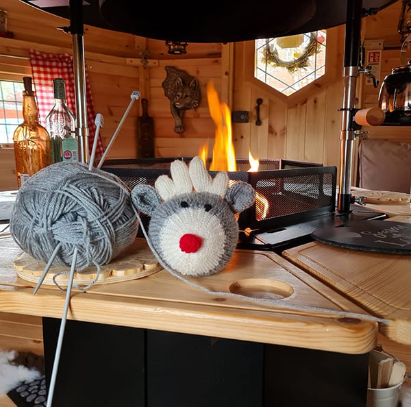 Knitting a reindeer in a BBQ Cabin.