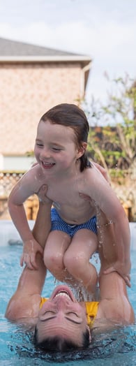 A mother and son enjoy the soothing water of a hot tub together by playing.