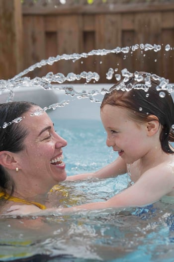 A mother and son enjoying the clean water of their hot tub monitored by their PureZone water monitor.