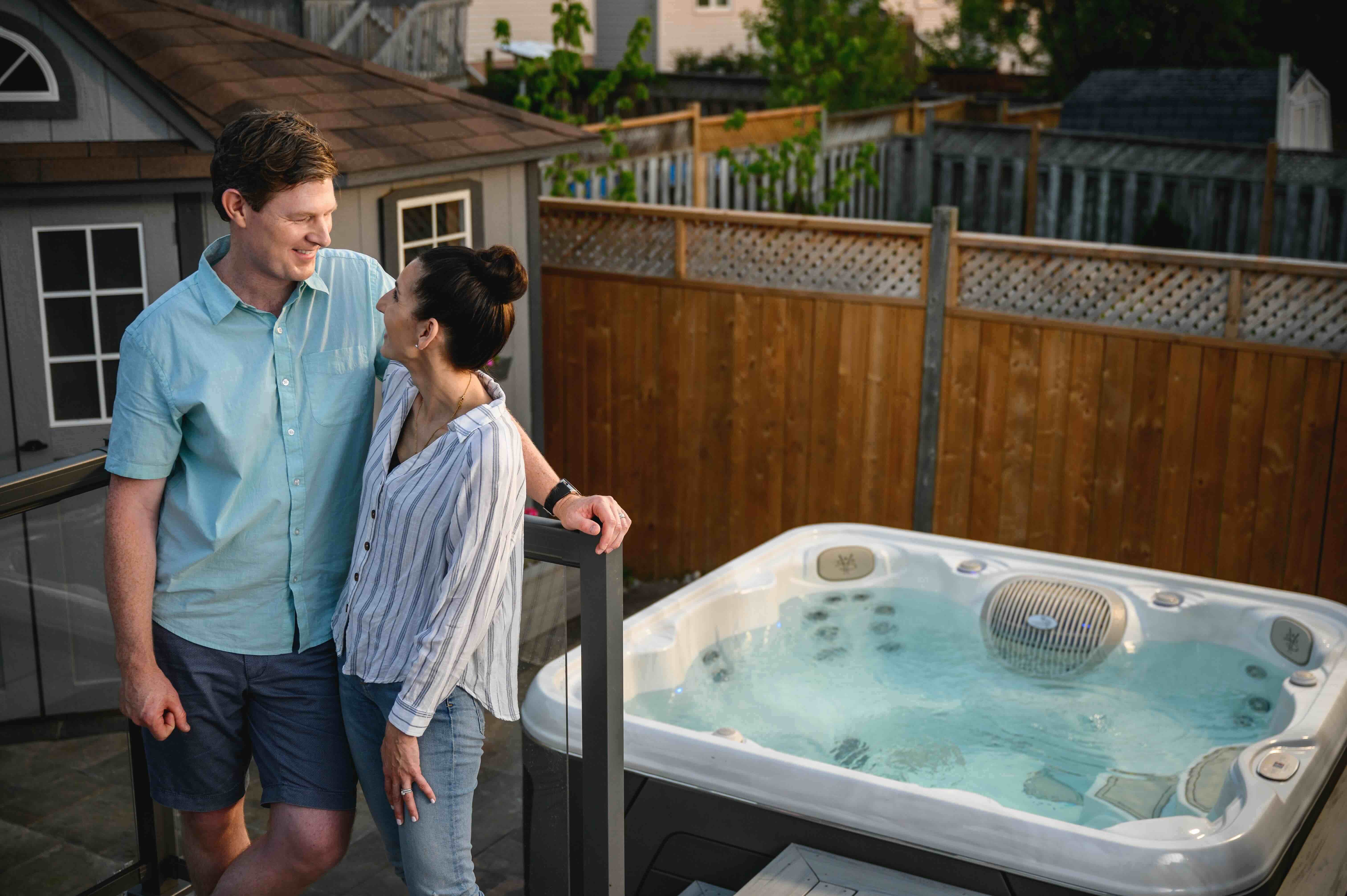 A couple stands in front of their new hot tub investment.