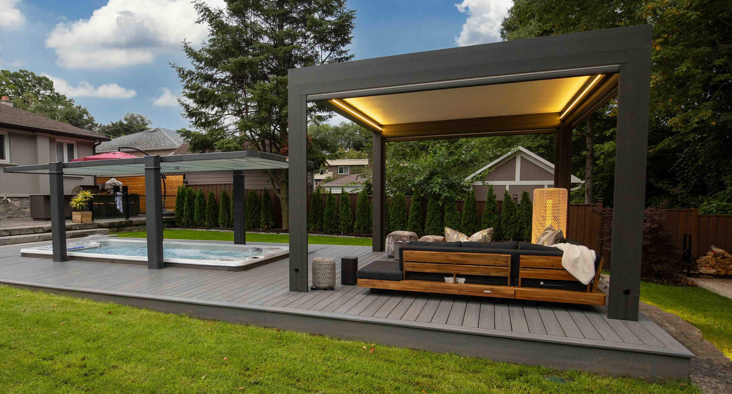 A glamorous hot tub under a Covana cover next to a gazebo with seating. 