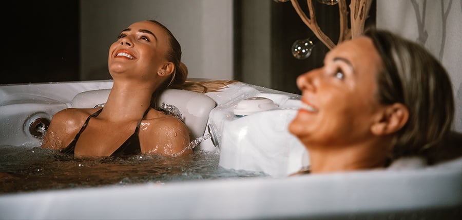 A mother and daughter experiencing the deep-tissue massage and hydrotherapy benefits of a premium Hydropool luxury hot tub, designed for ultimate relaxation and long-lasting quality in a Greater Manchester home.