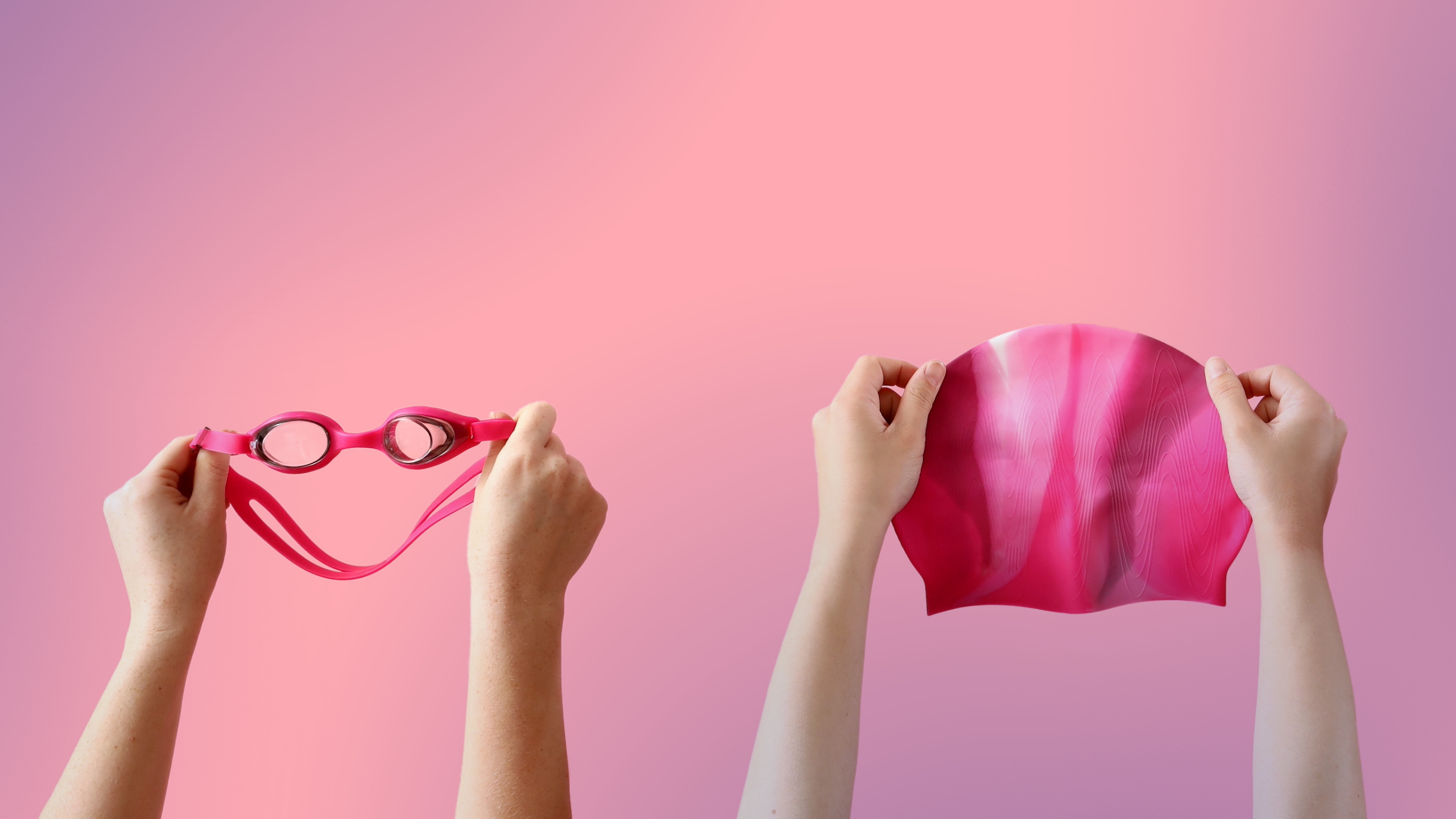 Two sets of hands holding up swimming accessories (goggles and a swim cap) to use in a resistance swim spa as recommended by Hydropool North West. 