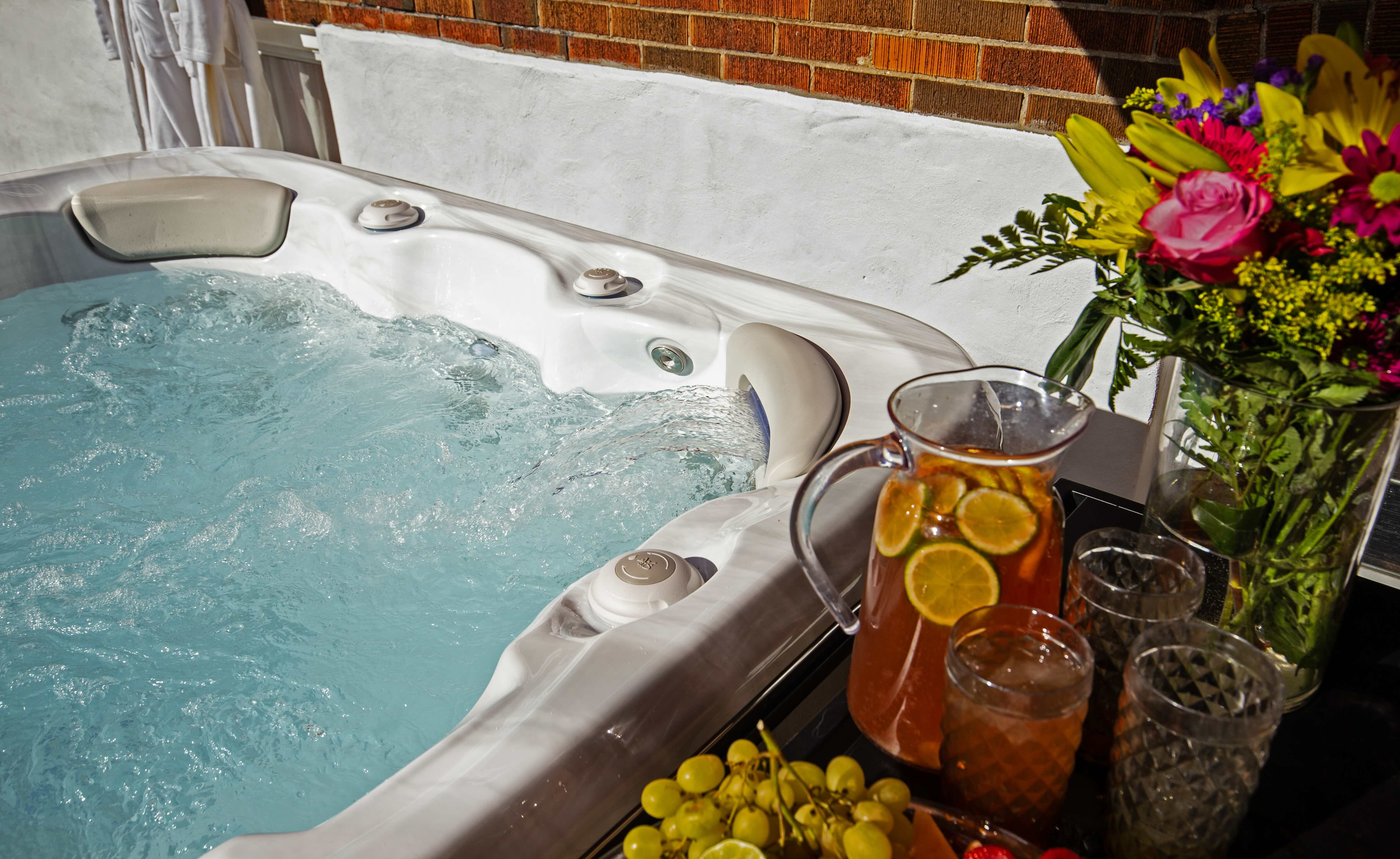 an example of a good quality hot tub with fruit and iced lemon tea pitcher on a bar built into the side of the hot tub cabinet. 