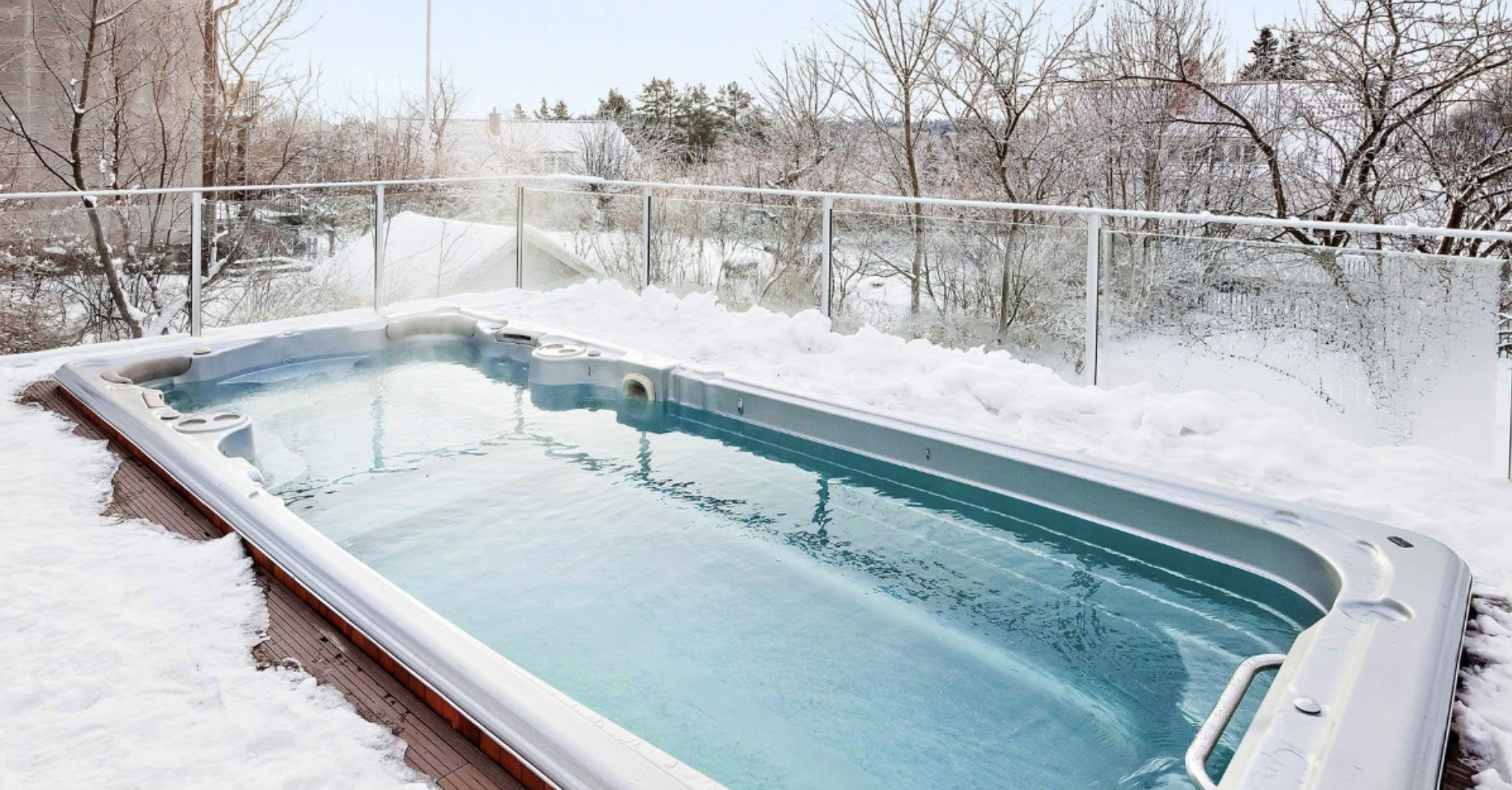 Hot tub with crystal clear water after being treated with the right chemicals, surrounded by snow.