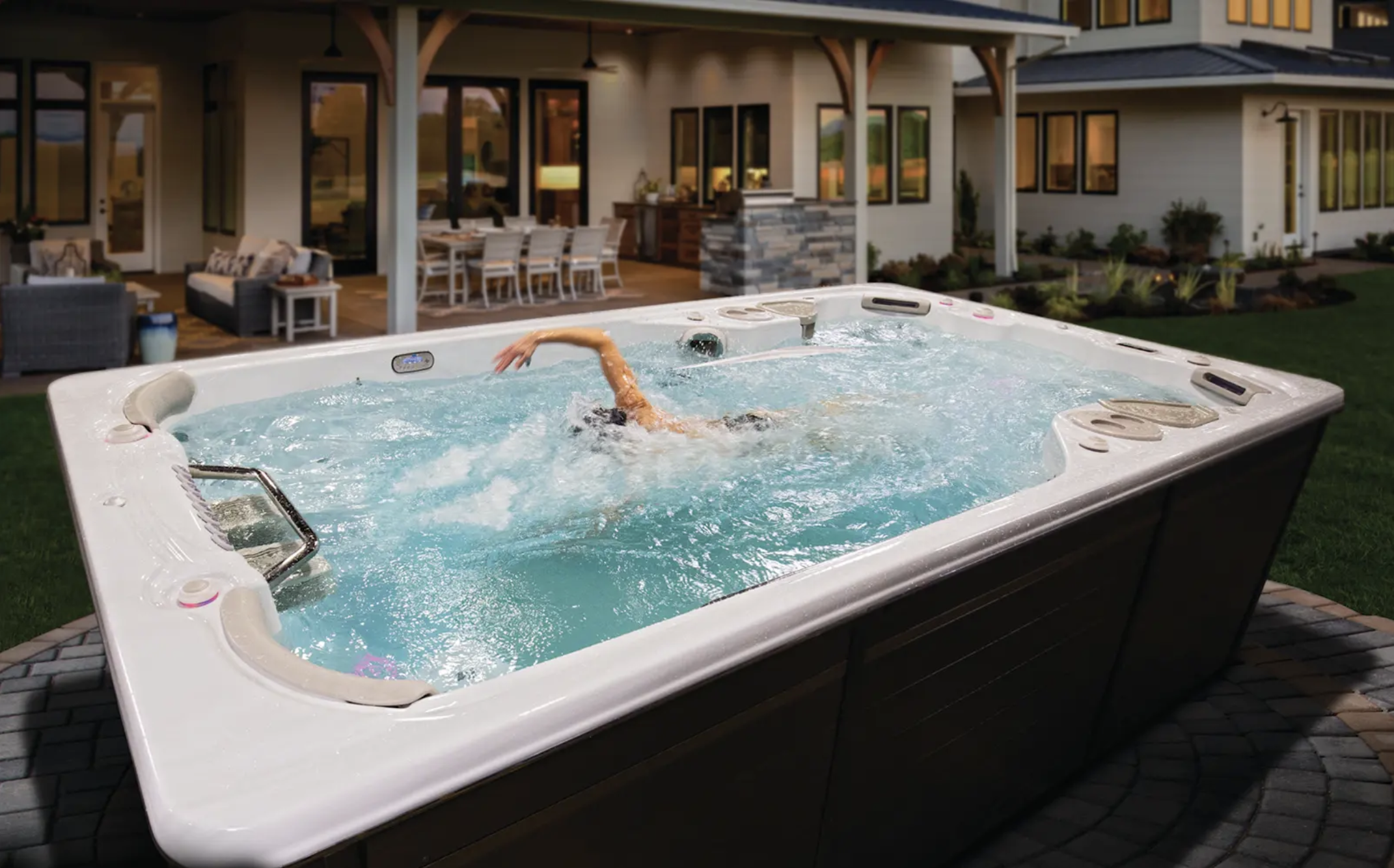 A person swimming in their swim spa in their back garden to help relieve pain. 